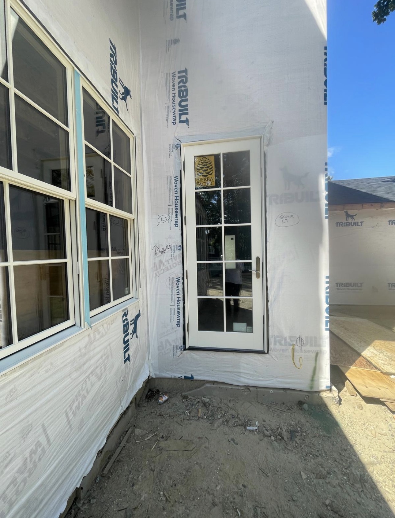 White 10-lite French door set in housewrap on a new elevation